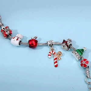 Close-up of Christmas charm bracelet with snowman, gift box, and candy cane charms