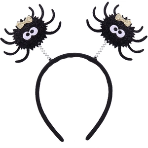 Detail of Halloween headband with black plush spiders, golden bows and spring attachments