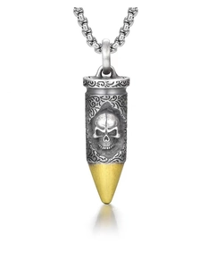 Macro detail of skull bullet pendant with vintage patterns and gold tip on box chain
