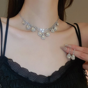 Close-up of silver drop tassel necklace and earrings set with sparkling rhinestones