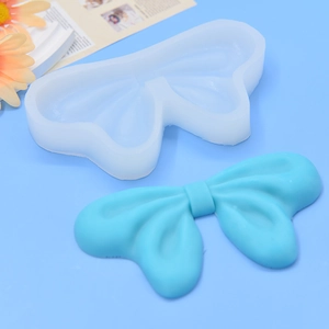 Bow tie silicone mold for DIY crafts with light blue finished resin bow and translucent mold