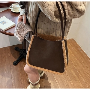 Detail of dark brown faux suede tote with plush lamb wool trim in a cozy winter setting