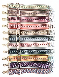 Detailed flat lay of eleven bohemian ethnic style adjustable cotton bag straps with gold buckles