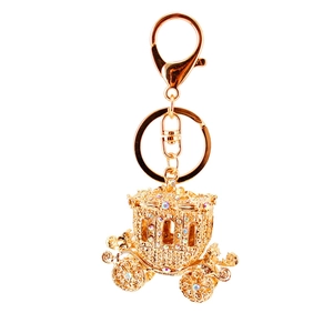 Sparkling gold pumpkin carriage keychain with embedded rhinestones on white background