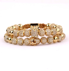 Detailed macro view of gold beaded bracelet set with micro-pave zircon crown charms