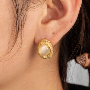 Chic gold-plated C-shaped earrings with faux pearl stones shown on a model's ear