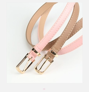 Detailed view of slim PU leather belts in pink and khaki with gold metal buckles