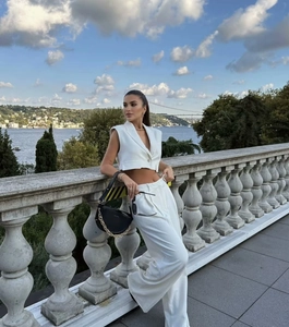 Outdoor shot of sleeveless short vest top and wide leg pants in white two piece set