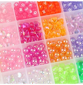 Close-up of colorful heart and alphabet beads in a 24-compartment storage box for DIY