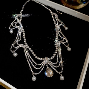 Detailed view of rhinestone fringe necklace with pearl accents and teardrop crystal pendant