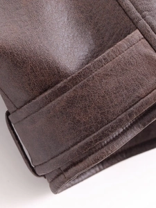 Detailed macro view of dark brown PU leather jacket cuff showing precise stitching texture