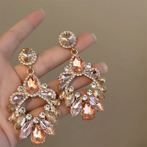 Exaggerated hollow geometric tassel earrings with champagne rhinestones in hand view