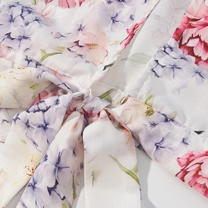 Détail du nœud avant avec imprimé floral rose sur un tissu en mousseline de soie