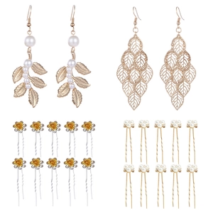 Detail of bridal jewelry set with golden leaves earrings and floral pearl hair pins