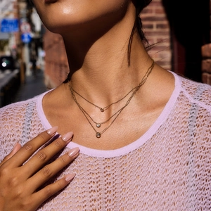 Three-layer gold stainless steel necklace with round zircon pendants on female model