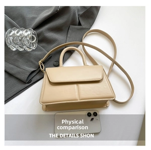 Detailed top view of a beige leather crossbody bag with stitched grooves and handle