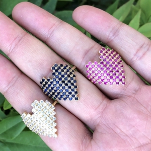 Detailed macro view of pixel-style heart rings with colorful pave crystals in 18K gold finish