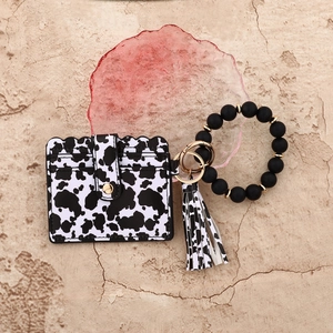 Detail of cow print wristlet keychain with leather card holder and silicone beads