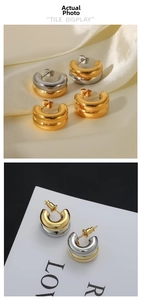 Macro detail of chunky gold and silver plated C-shaped earrings on luxury silk background