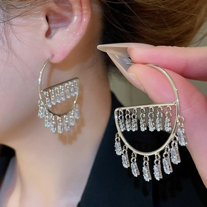 Detail shot of silver earrings with trapezoid zircons and hollow tassel design
