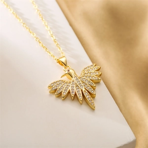 Dettaglio di una collana con ciondolo a forma di uccello dorato con piccoli cristalli