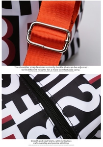 Close-up of travel bag detailing adjustable orange strap and sturdy silver metal buckles