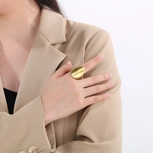 Minimalist gold brushed stainless steel oval ring worn by a model in office attire