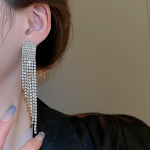 Gros plan de boucles d'oreilles pendantes argentées avec strass brillants sur le mannequin
