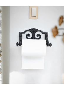 Detail of vintage cast iron paper towel holder with classic scrolls and matte finish