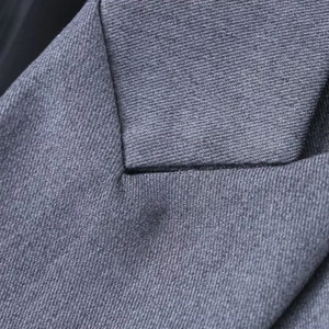 Gros plan détaillé de la texture tissée grise et des coutures du revers de veste