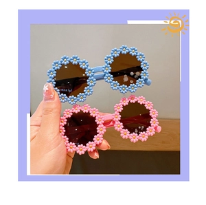 Detail shot of cute daisy-shaped kids sunglasses in blue and pink pastel colors