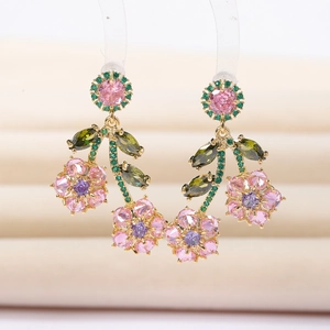 Elegant floral drop earrings with colorful zircons and golden base on a soft beige background