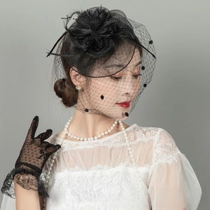 Detail of vintage black lace fascinator hat with elegant mesh veil and feathers