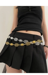 Detail view of retro mixed metal waist chain with textured oval links on a black skirt