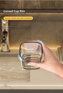 Close-up of translucent grey travel toothbrush cup showing the smooth curved rim design