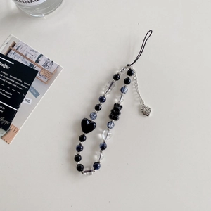 Detail of beaded phone charm with black heart, bear pendants and silver heart tag