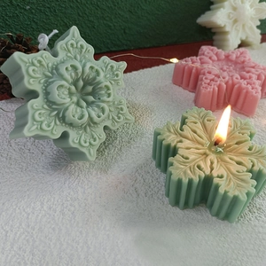 Handmade snowflake scented candles in pink green and white for festive winter decor