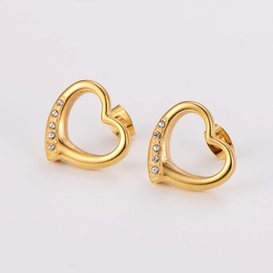 Golden heart earrings set with small sparkling zircons and tassels on a clean white background