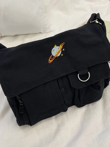 Black canvas messenger bag with celestial planet embroidery and adjustable shoulder strap
