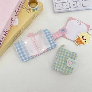 Detailed view of mini checkered fabric photo albums with transparent inner sleeves and snap button