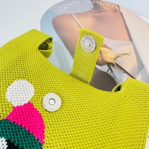 Detail of the silver magnetic clasp and knit texture on this green handmade crossbody bag