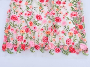 Gros plan de la broderie florale sur tulle blanc pour une robe d'été élégante