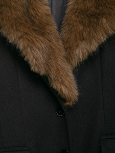 Detail of wool coat featuring a brown faux fur collar and black textured wool fabric