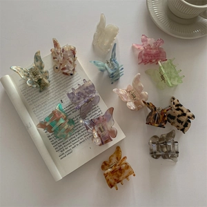 French style acetate butterfly hair claws in various marble colors on an aesthetic background