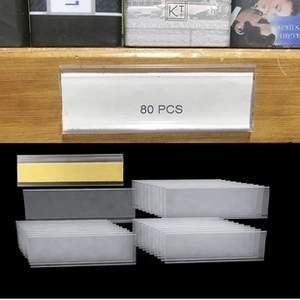 Detailansicht von 80 Stück transparenten Kunststoff-Preisetikettenhaltern auf Holz