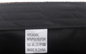 Dettaglio dell'etichetta con composizione materiale 10% lana e 90% poliestere per il cappello