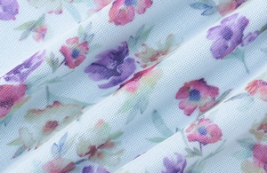 Close-up of sheer double-layer mesh fabric with blue and purple floral print patterns