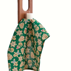 Christmas green fabric napkin with festive gingerbread man and tree prints for table decor