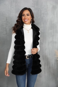 Vue de face du gilet en fausse fourrure noire avec fermeture éclair sur un pull blanc