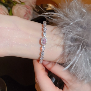 Close-up of luxury bracelet with pink oval stone and pear-shaped zircon on wrist